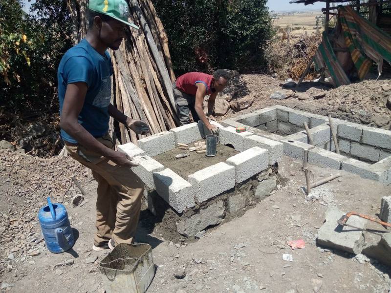 Artisans assembling the interlocking superstructure panels on a pit